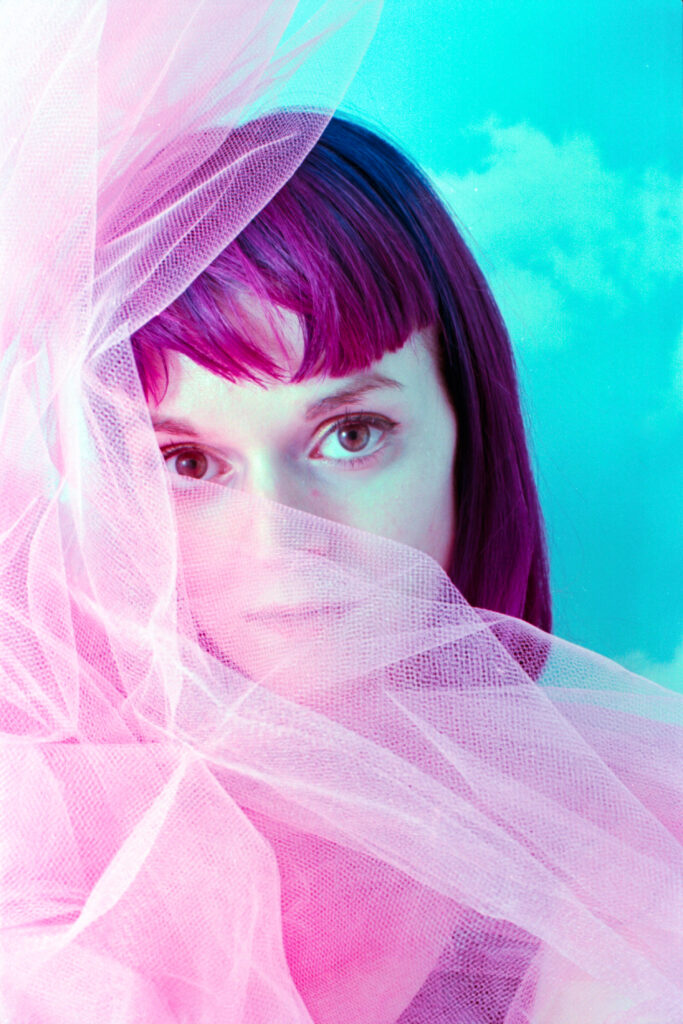 portrait of film photographer Amanda Wood half-covered in pink tulle