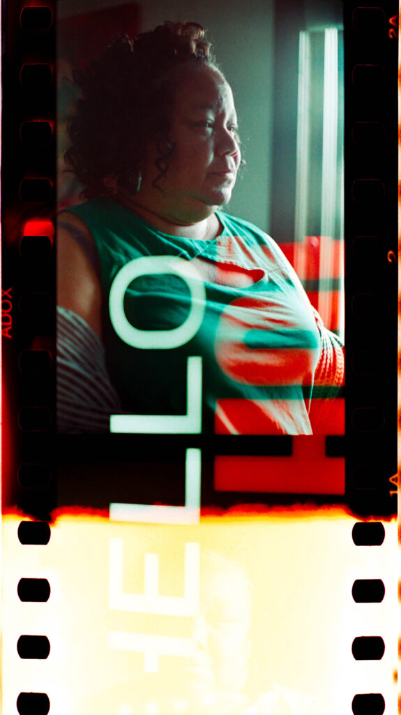First-of-the-roll, double-exposure portrait of a black woman sitting in the subtle light of a window in the early morning