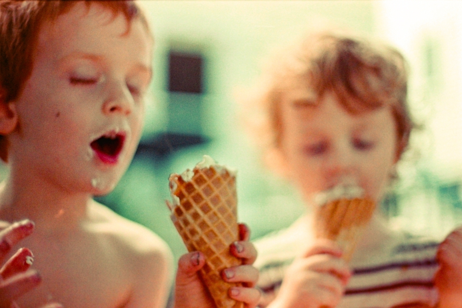 Photograph of two little boys eating ice-cream on their backyard, basking in a cinematic light
