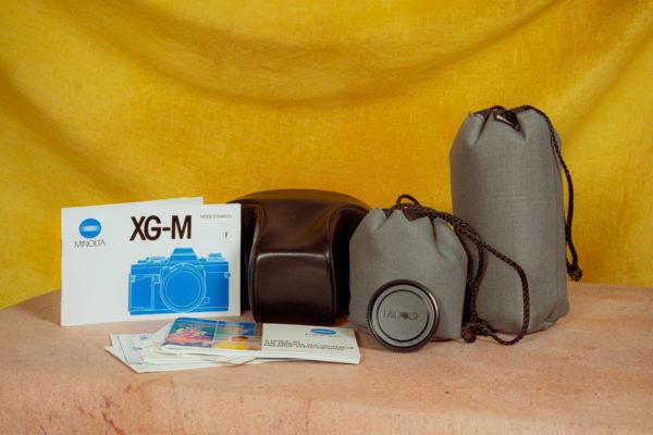 Product photo of the camera Minolta XGM and the two extra lenses all safely stored in their respective cases