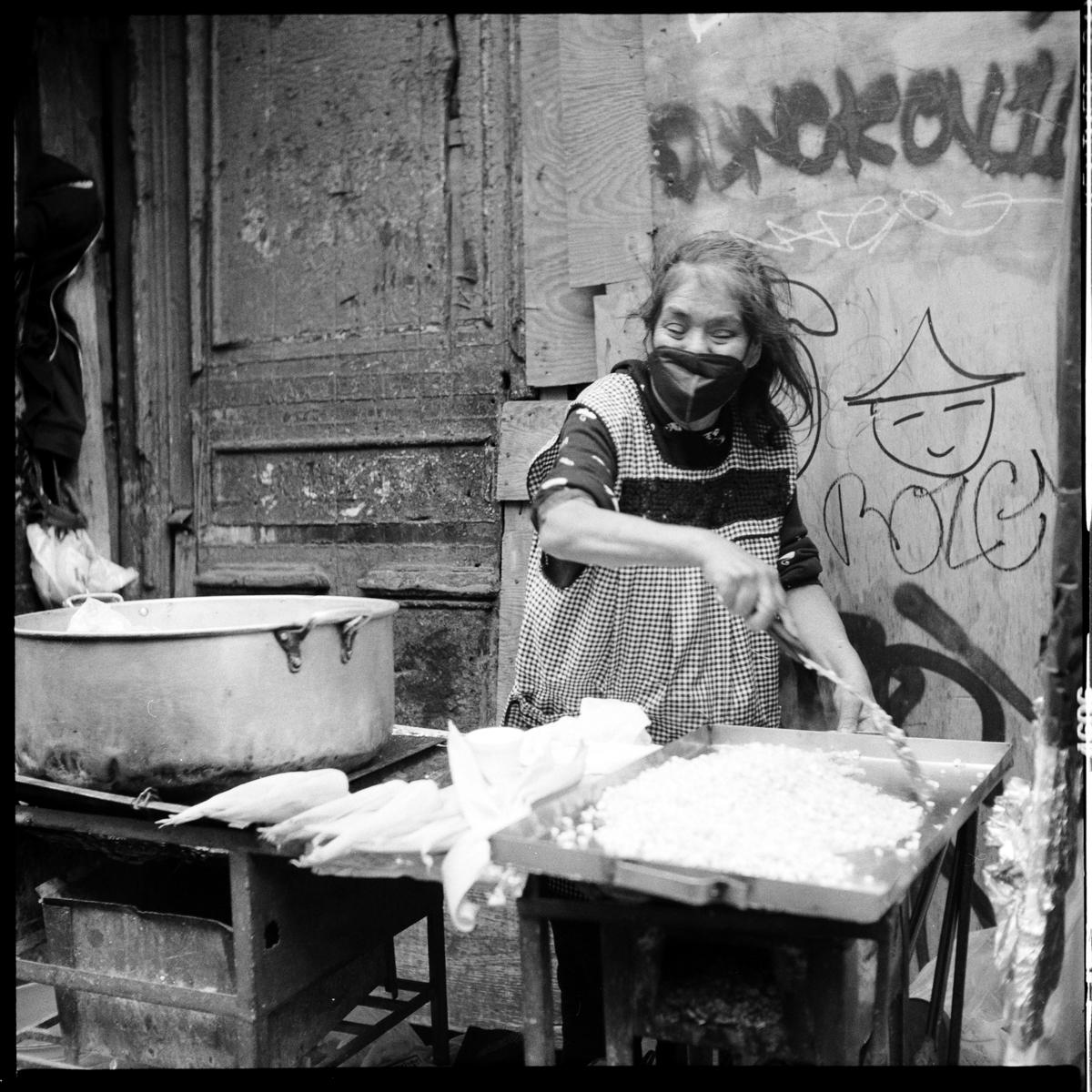 analog black-and-white street photograph of an elderly woman street vendor in Mexico City