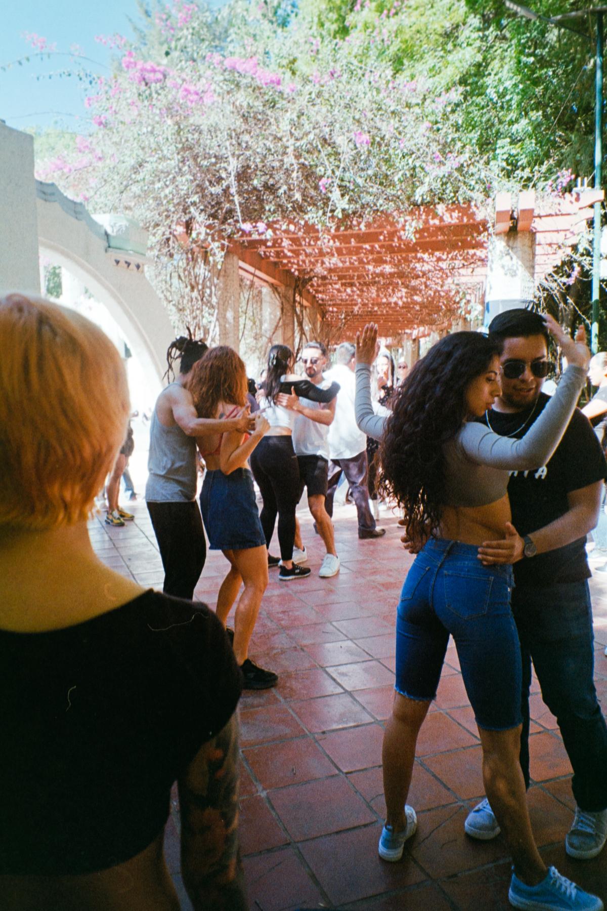 analog street photograph of couples dancing in Parque México on a Saturday afternoon